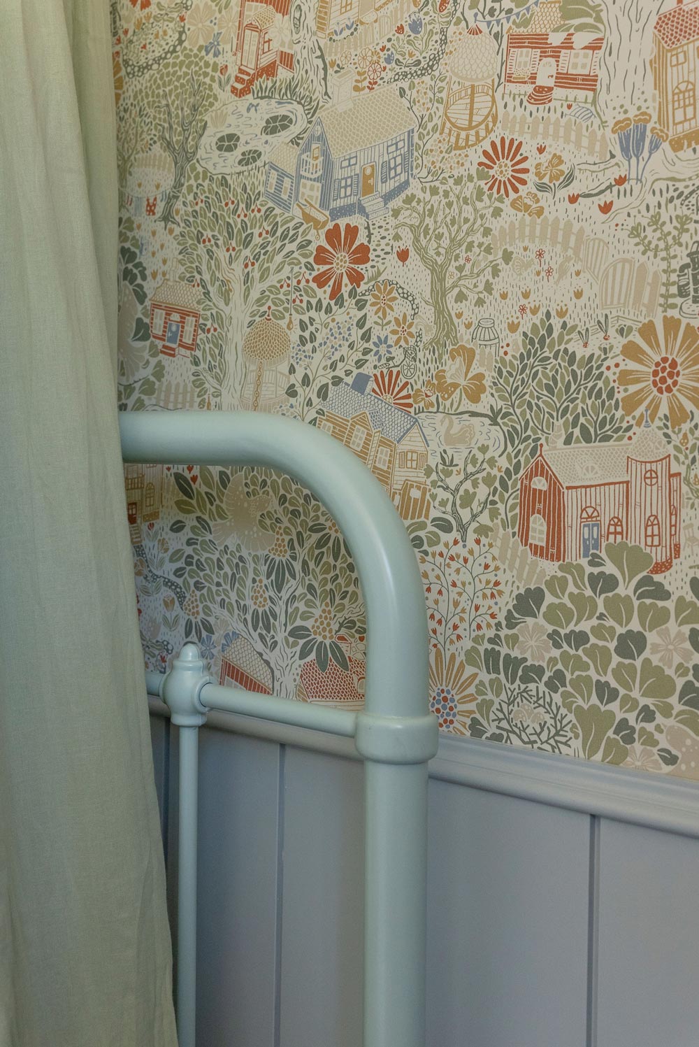 Closeup of floral wallpaper, and pastel blue metal bed frame. Closeup of floral wallpaper, and pastel blue metal bed frame.