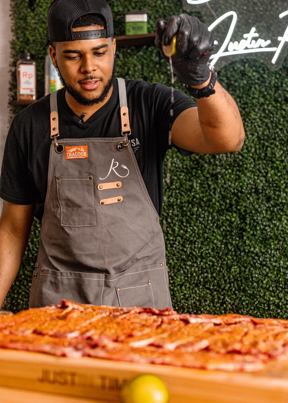 Chef seasoning riblets on cutting board. Chef seasoning riblets on cutting board.