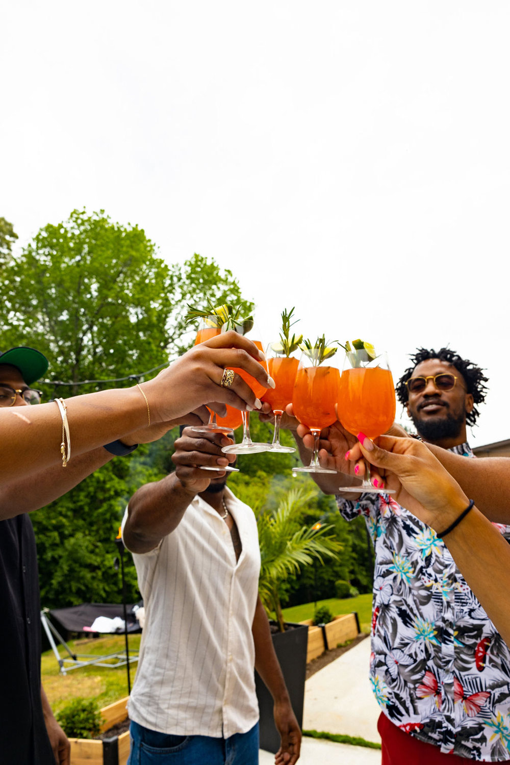 A group of people toasting glasses with garnished mocktails. A group of people toasting glasses with garnished mocktails.