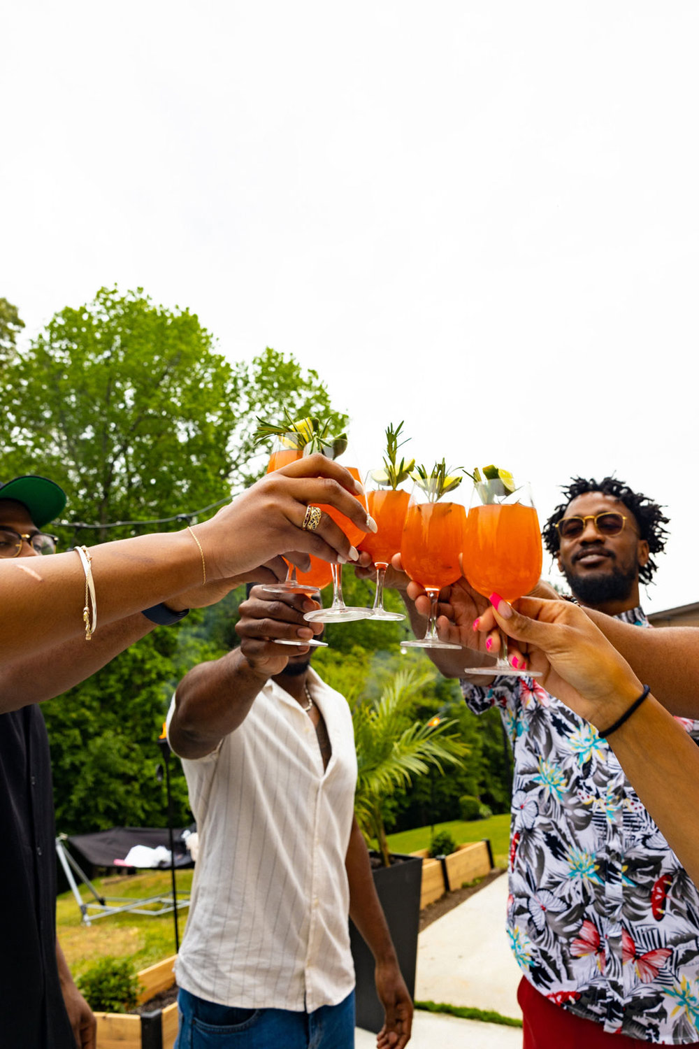 A group of people toasting glasses with garnished mocktails. 