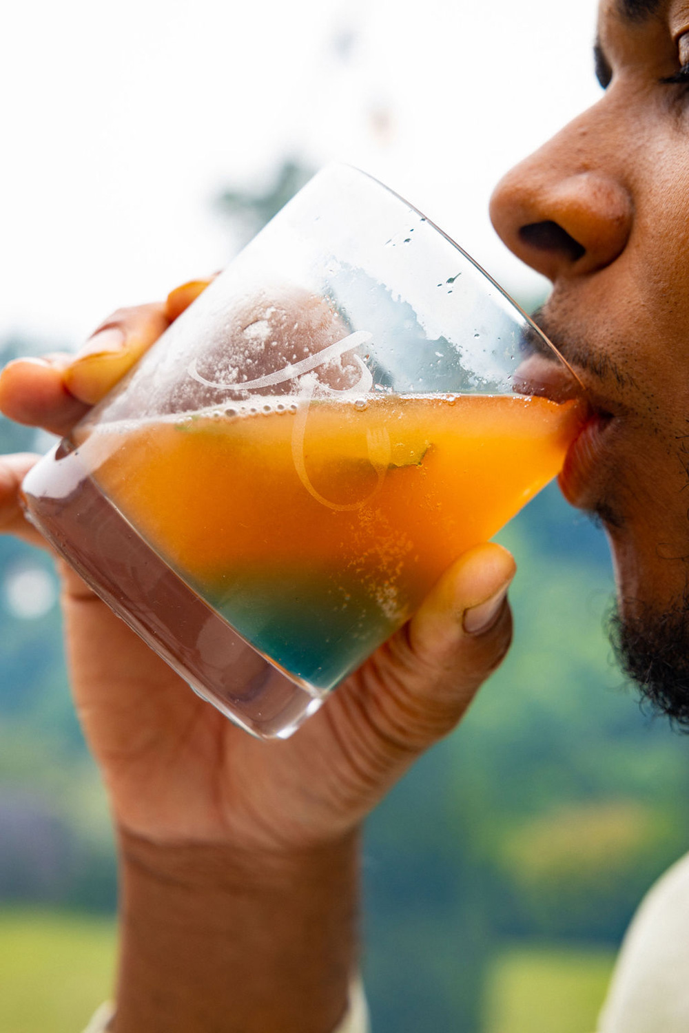 A man taking a sip of a mocktail.
