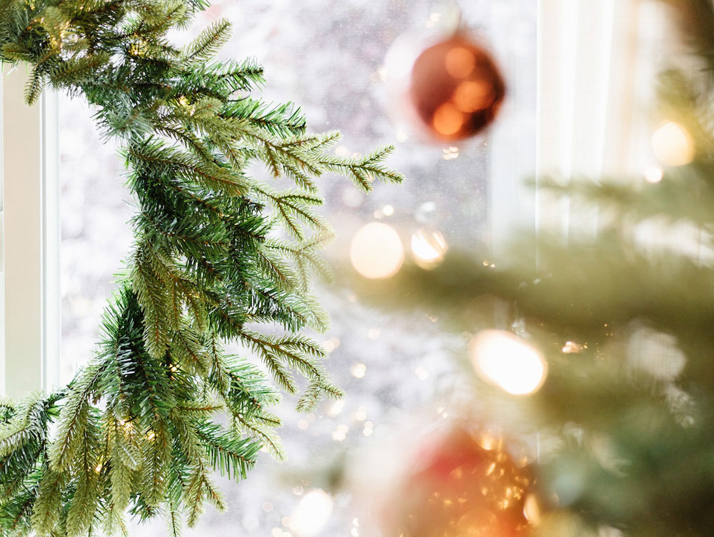Focal shot of a wreath and blurred ornaments and tree branches