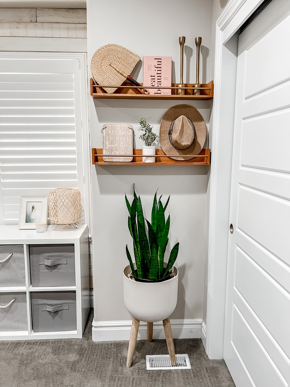 Vertical shot of decorated shelves above and floor plant. Vertical shot of decorated shelves above and floor plant.