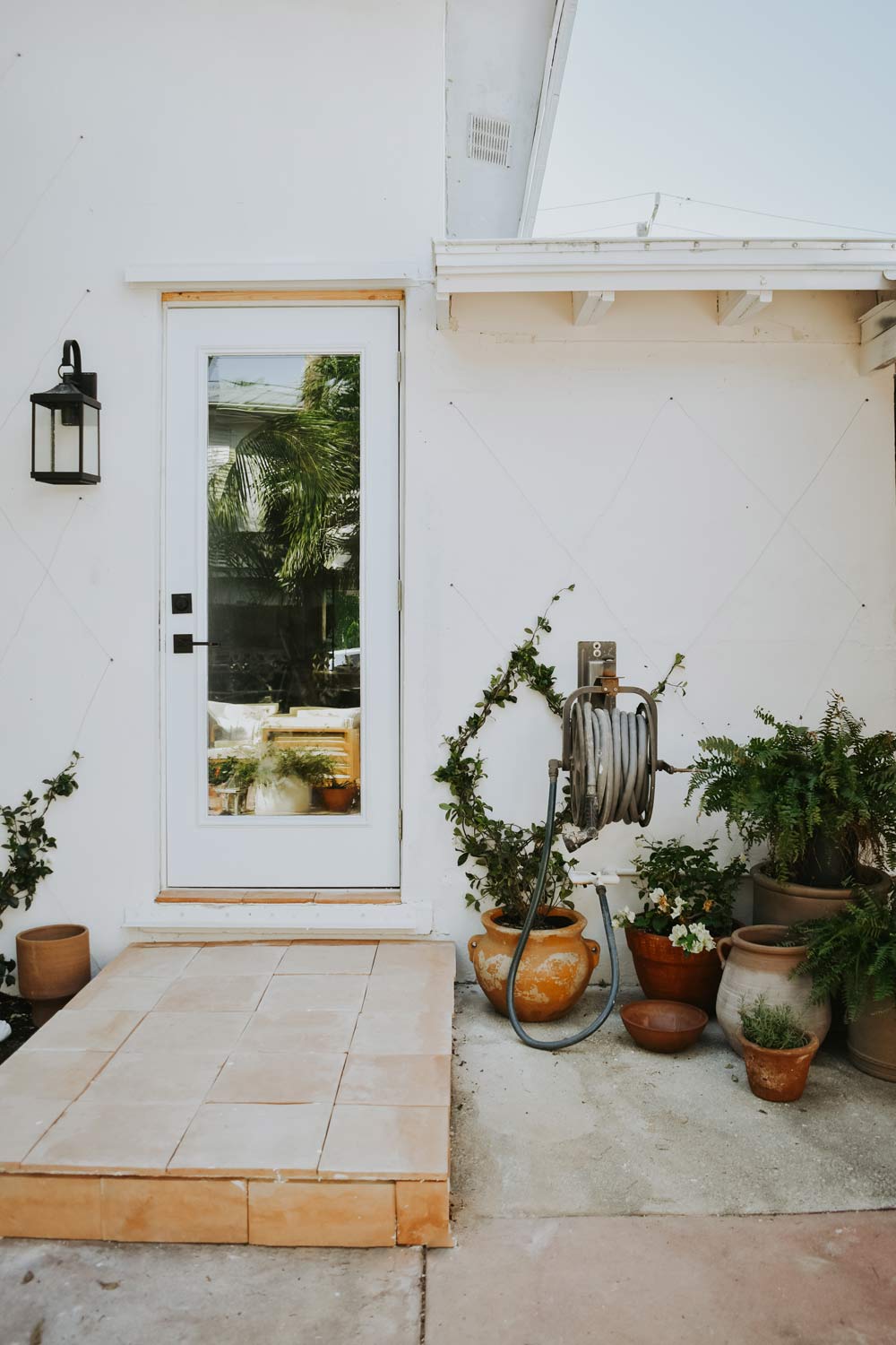 A doorway with potted plants next to it. A doorway with potted plants next to it.