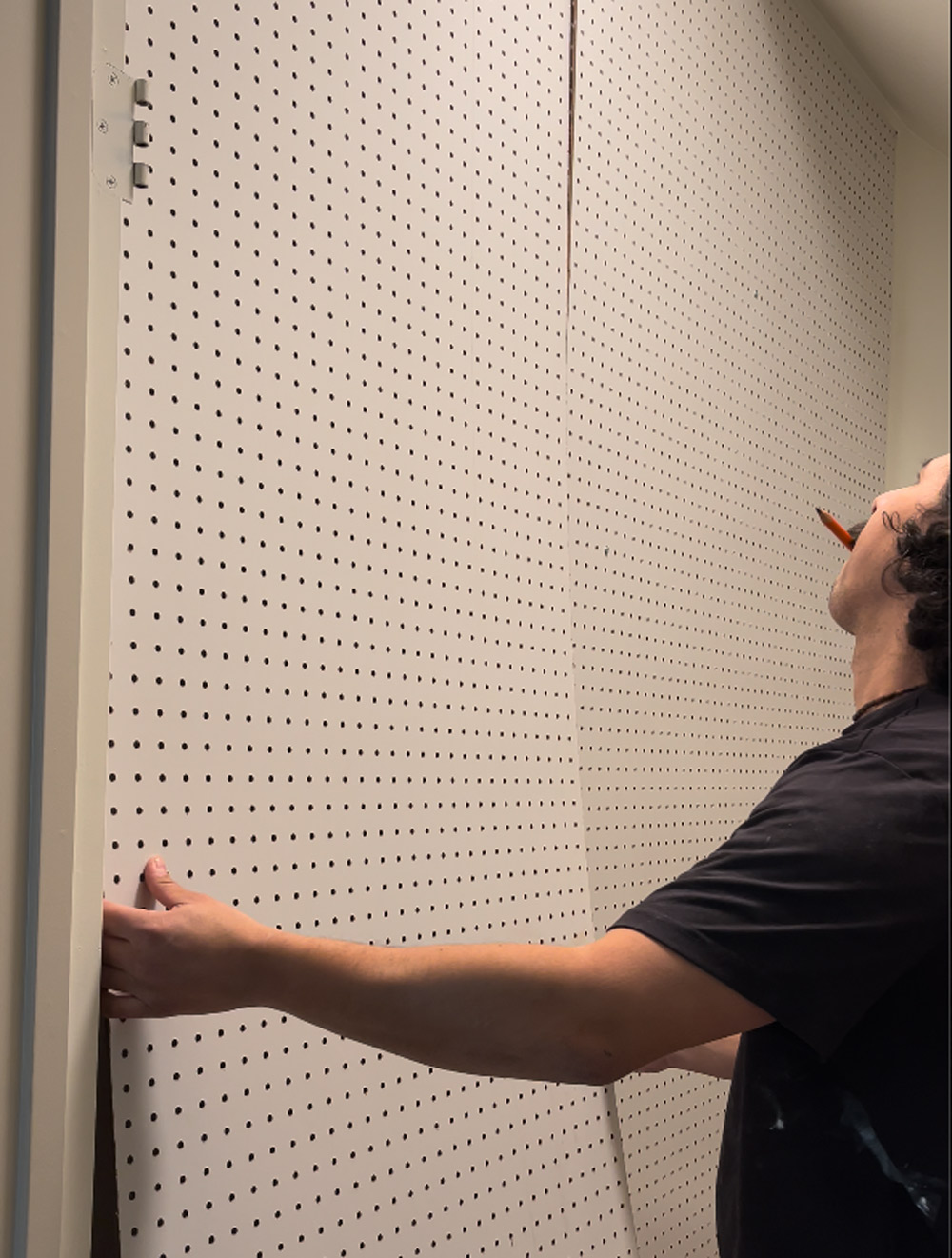 Pegboard held up being installed on a wall.