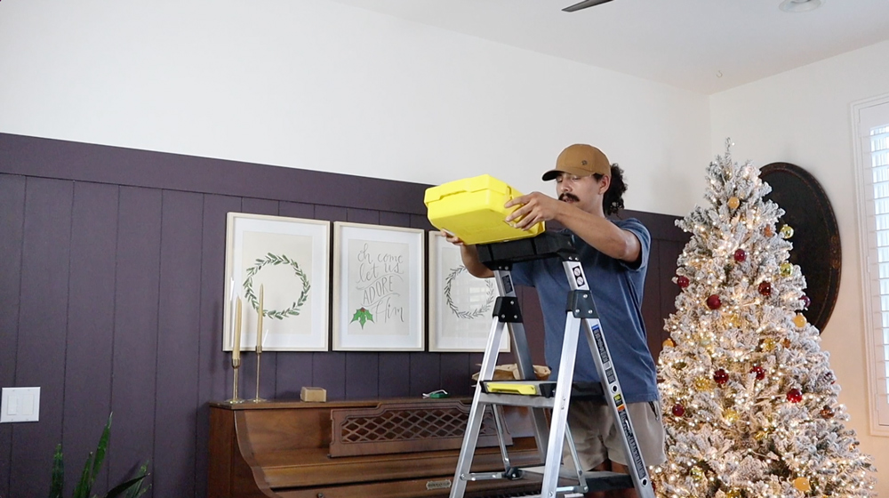 Man standing on a ladder holding a detachable bucket. Man standing on a ladder holding a detachable bucket.