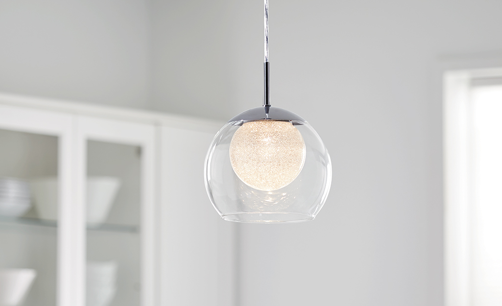 An LED light bulb in a glass pendant fixture.