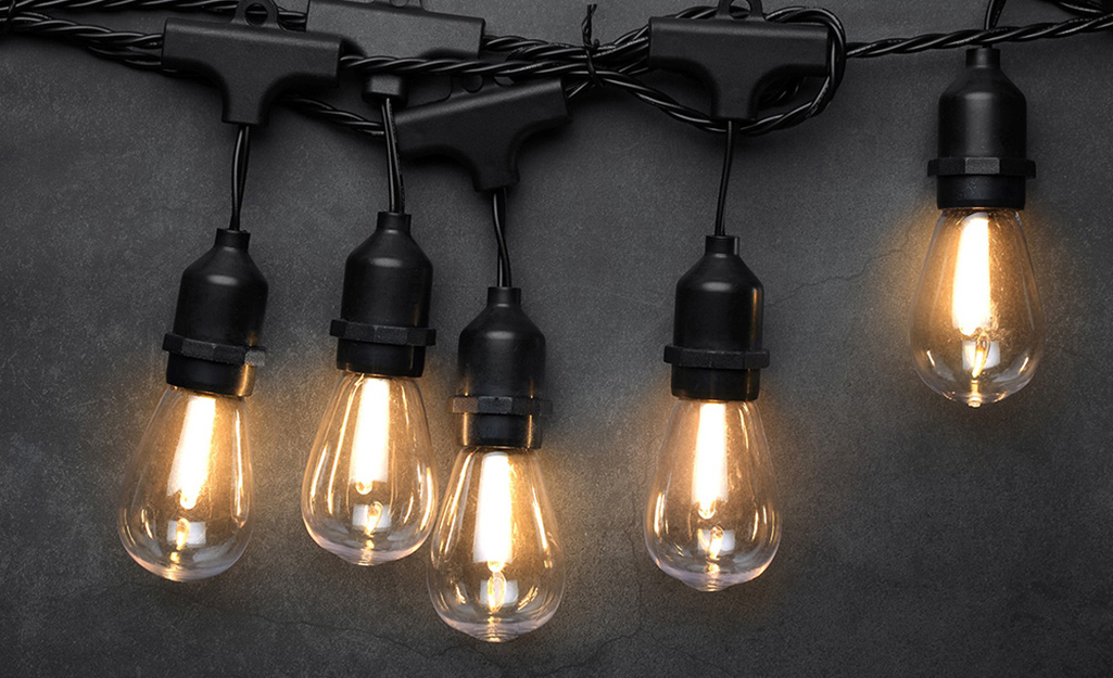 Edison-style LED bulbs hang on string lights. 