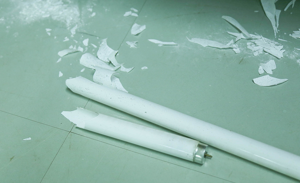 A broken fluorescent light tube reveals the toxic glass and debris inside.
