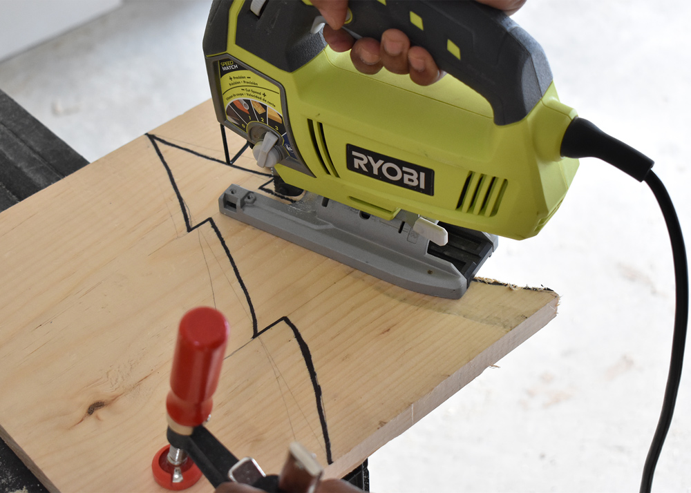 Person using jigsaw to cut tree shape.