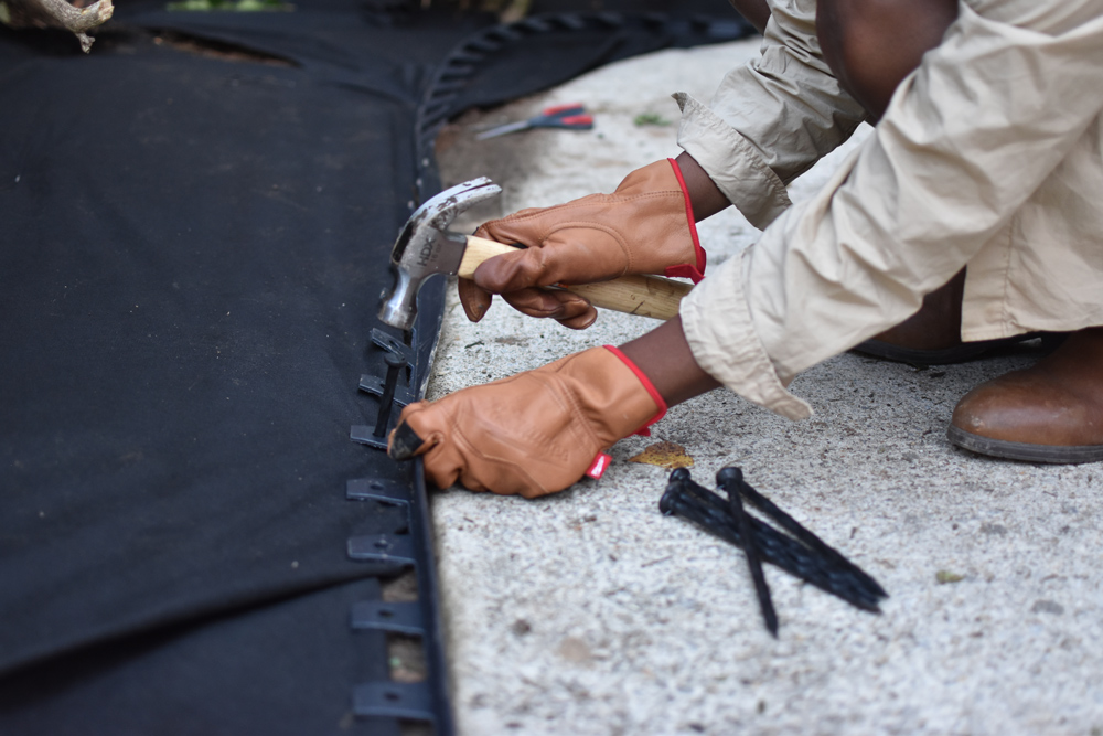 Close up of a woman using a hammer to place edging spikes with the Vigoro no dig edging. Close up of a woman using a hammer to place edging spikes with the Vigoro no dig edging.