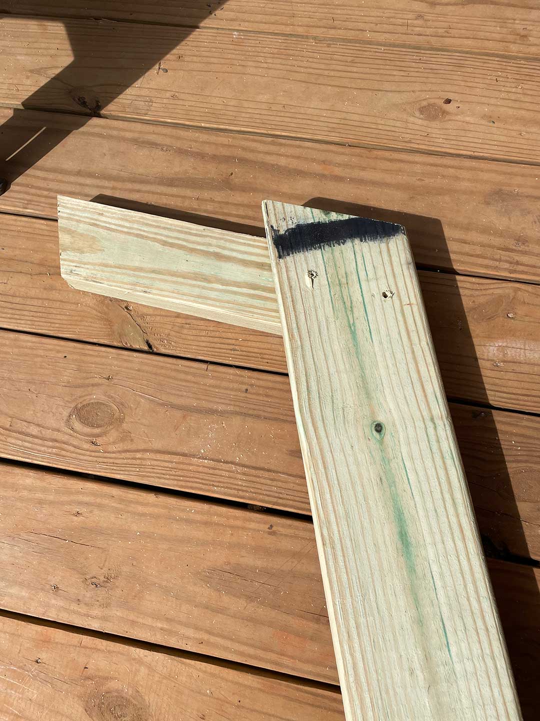 Two pieces of wood laid over a wood deck.