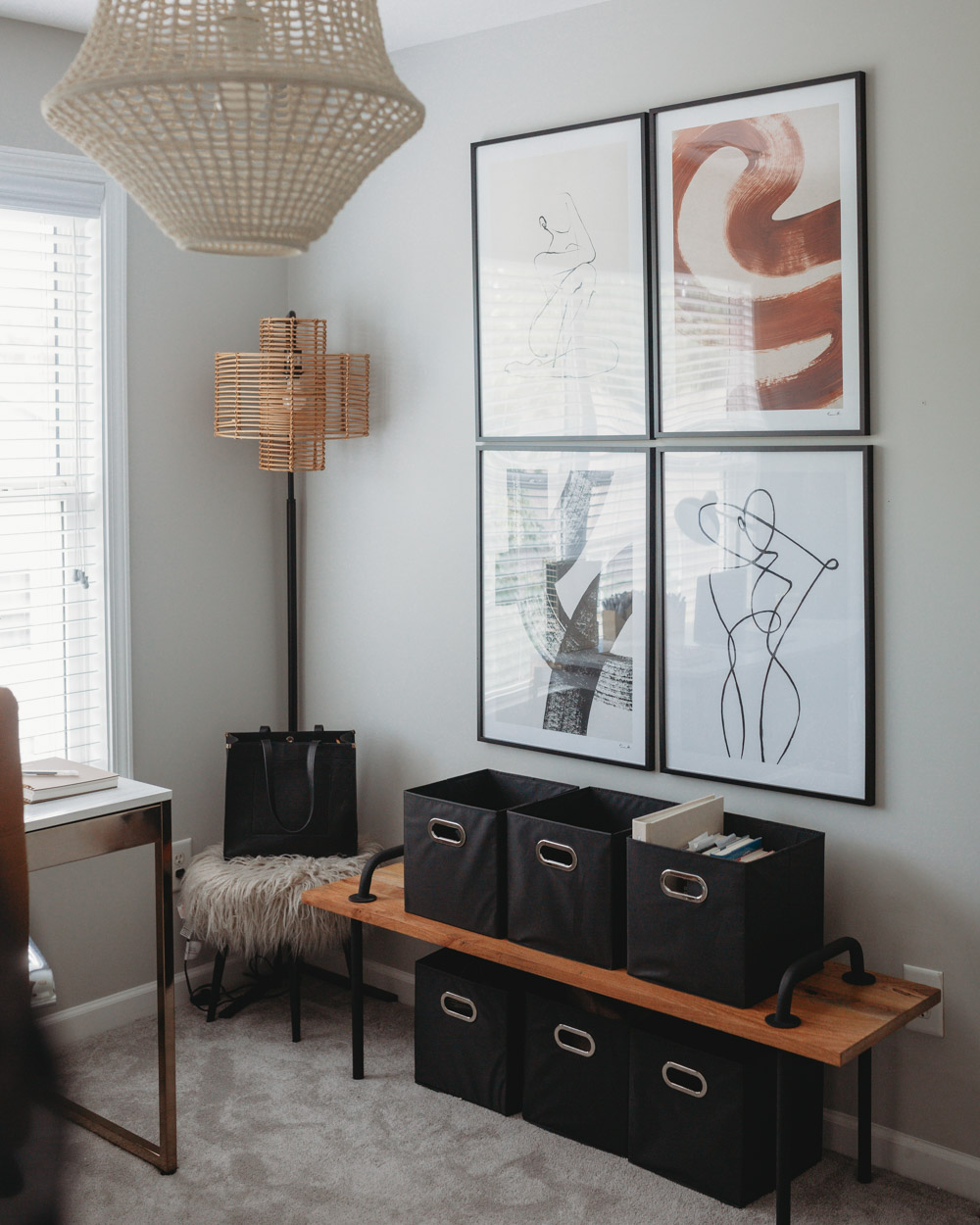 A room featuring an industrial bench, bohemian floor lamp, and large artwork on the walls.
