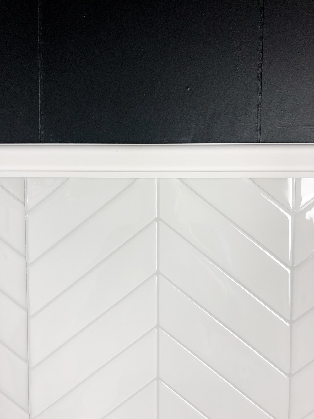  White peel and stick herringbone tile with white trim.