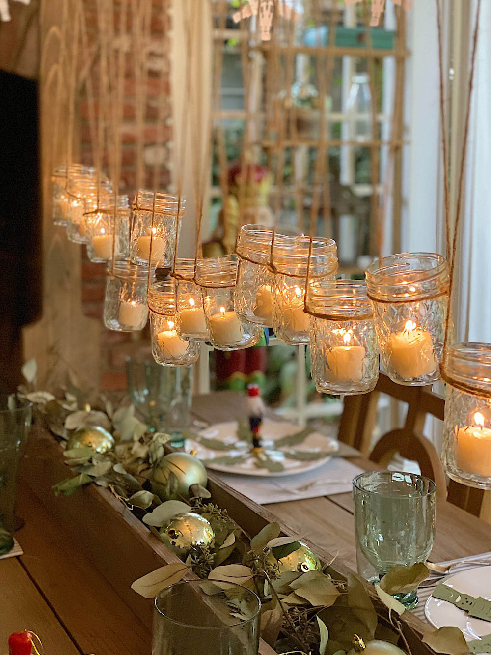 Table styled with hanging votive candles and ornaments