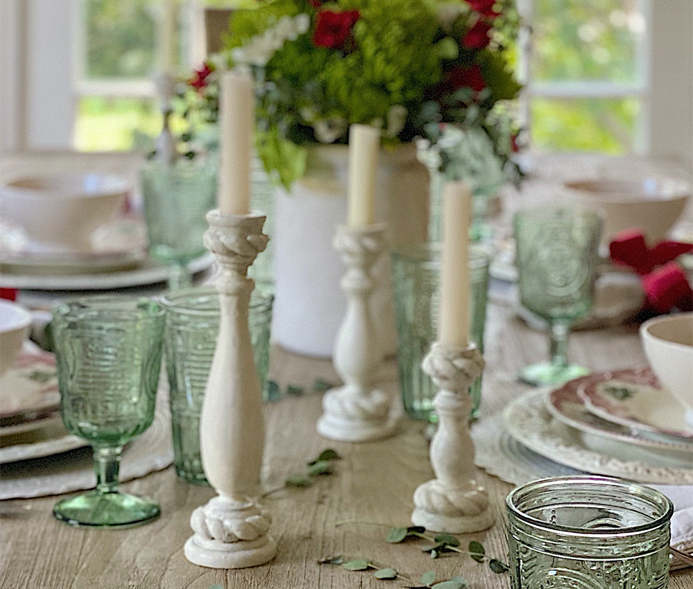 Candles and flowers on a dining table spread.