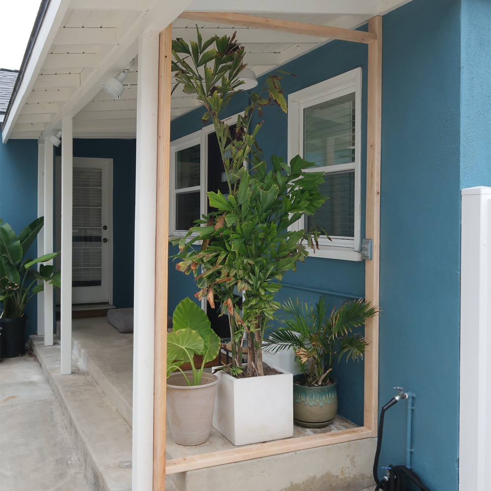 Open wood frame with potted plants in the center.