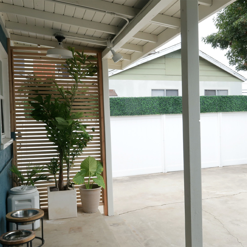 Left angle of completed privacy fence and three potted plants.