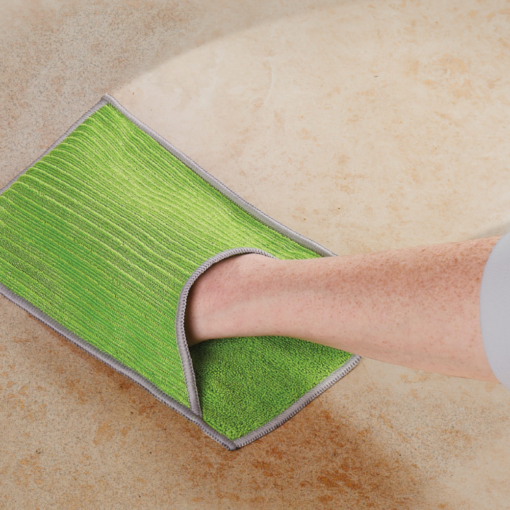 A person cleans a counter with a microfiber cloth.