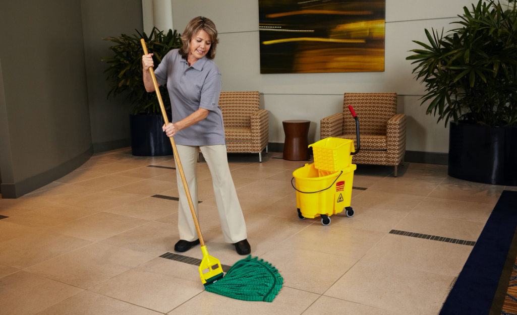 A person uses a microfiber tube mop.