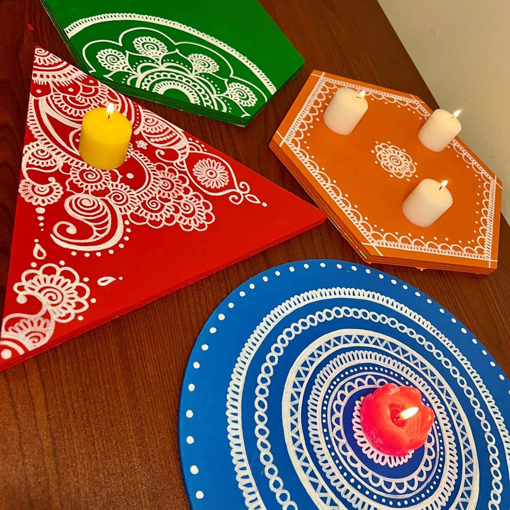 Various Diwali trays with candles placed on top. 