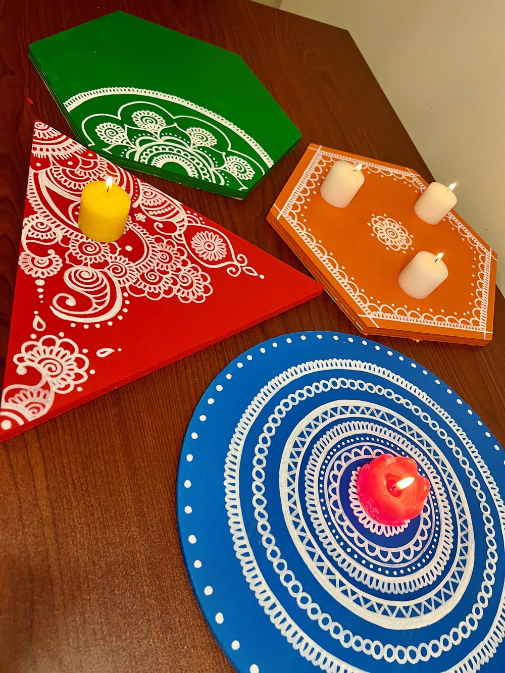 Various Diwali trays with candles placed on top. 