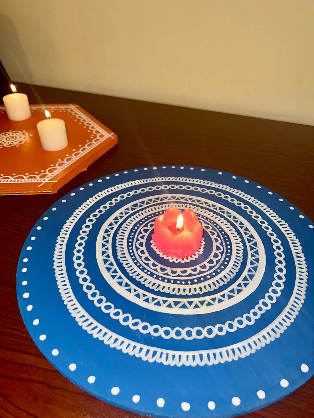 DIY painted Diwali tray with a flower candle in the center.