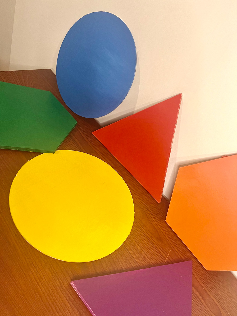 Six wooden shapes painted with various colors.