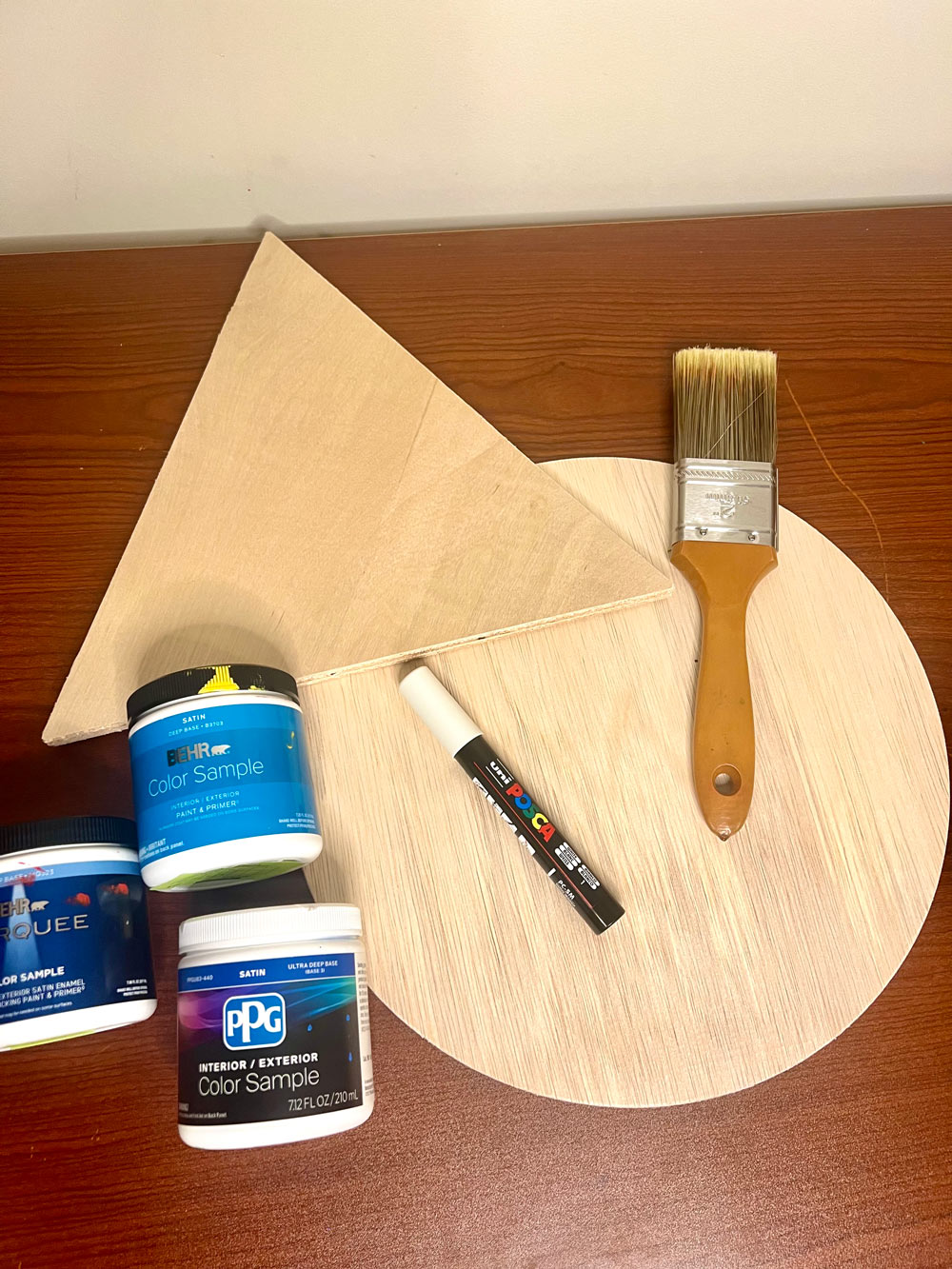 Flat lay photo of materials including various wooden shapes, paint, and paintbrush.