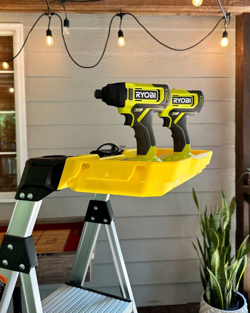 Ryobi tools inside of a bucket attached to a ladder. Ryobi tools inside of a bucket attached to a ladder.