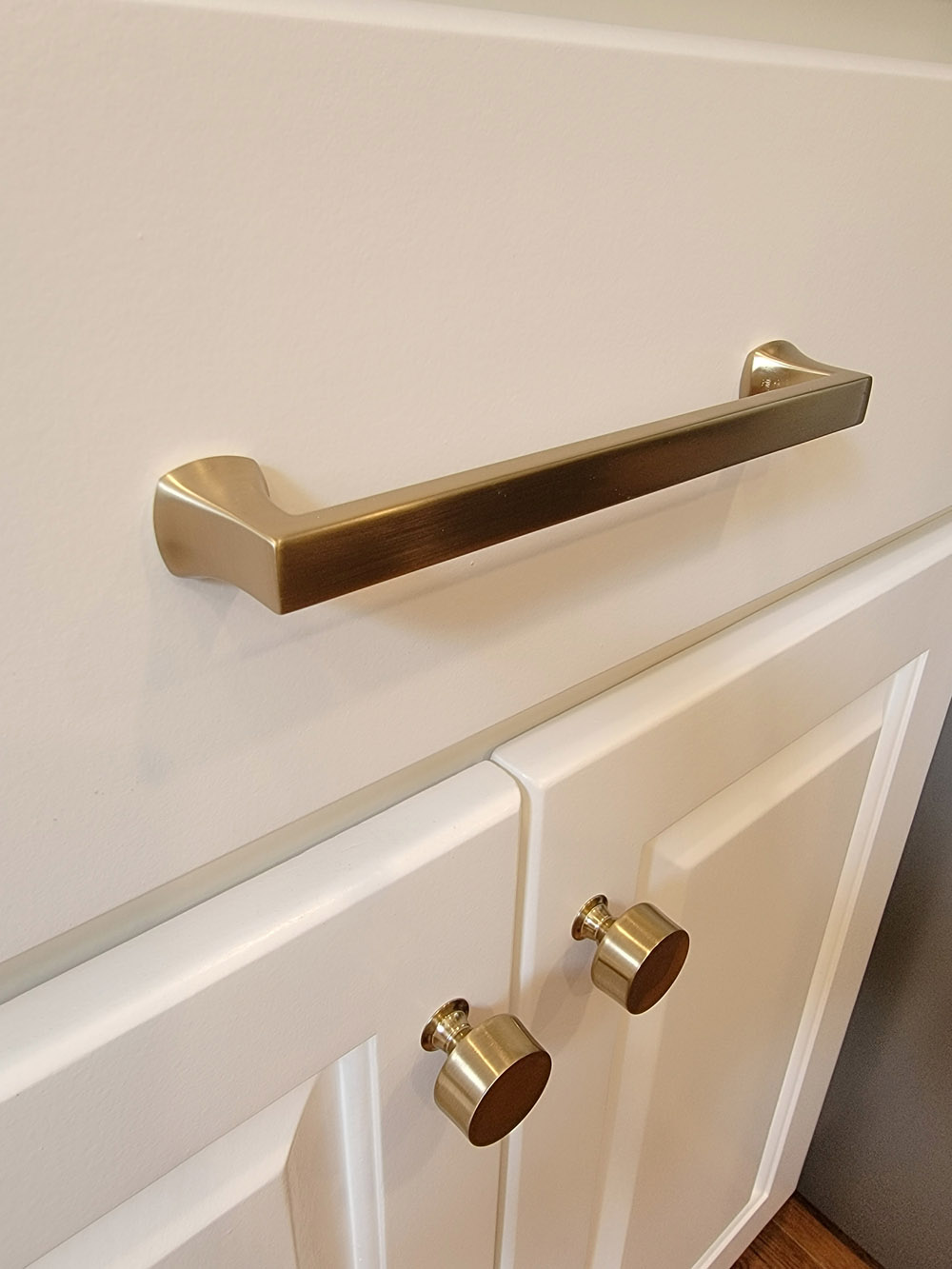 Updated cabinet fixture painted white with brass knobs and pull.