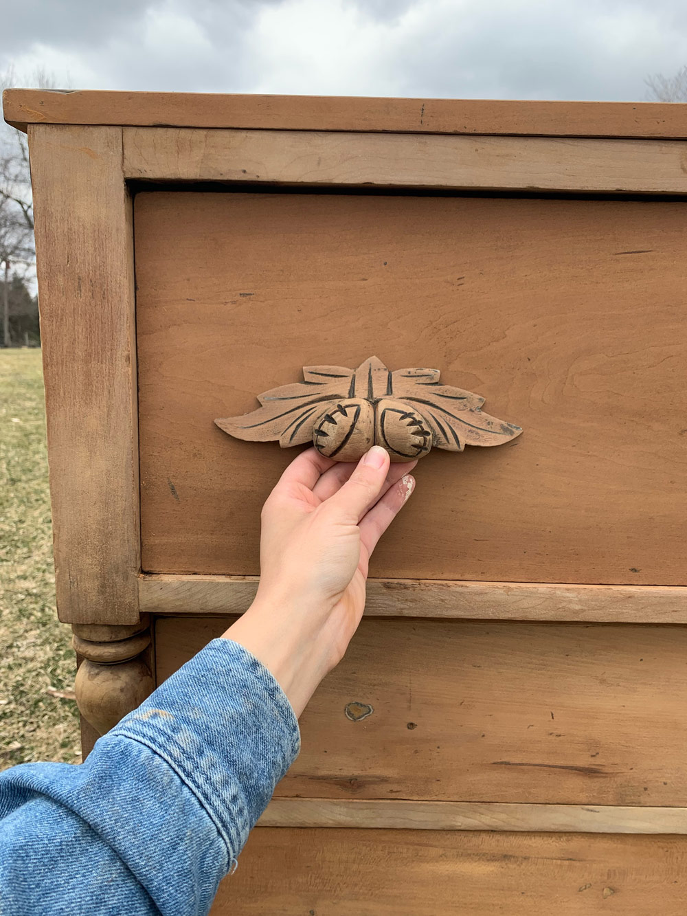 The stripped handles of the antique wooden dresser.