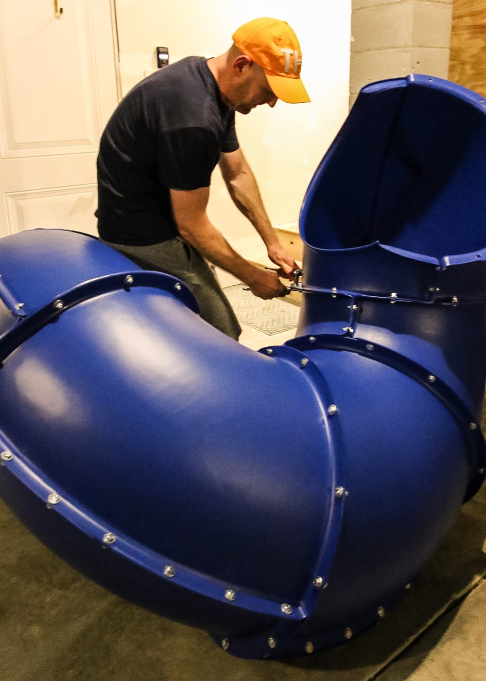 A man putting together a large blue slide