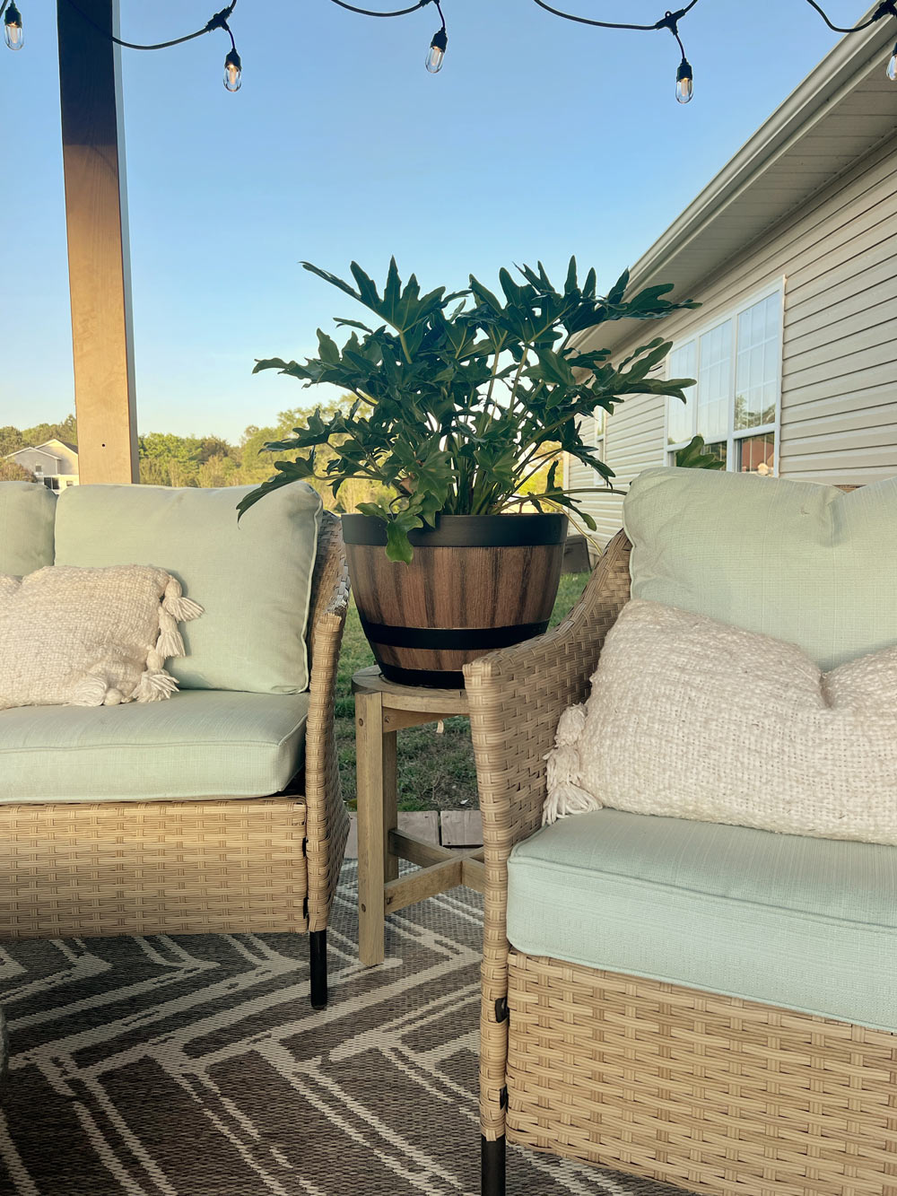 Two patio chairs with pillows, with a barrel planter in between. Two patio chairs with pillows, with a barrel planter in between.