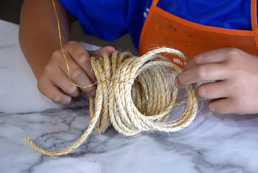 Fanned out bent rope being manipulated to form a pumpkin shape.