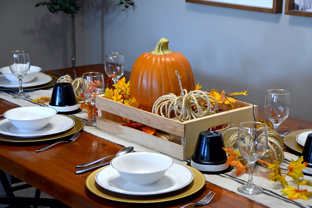 Thanksgiving table fully decorated with dinnerware set and decorations.