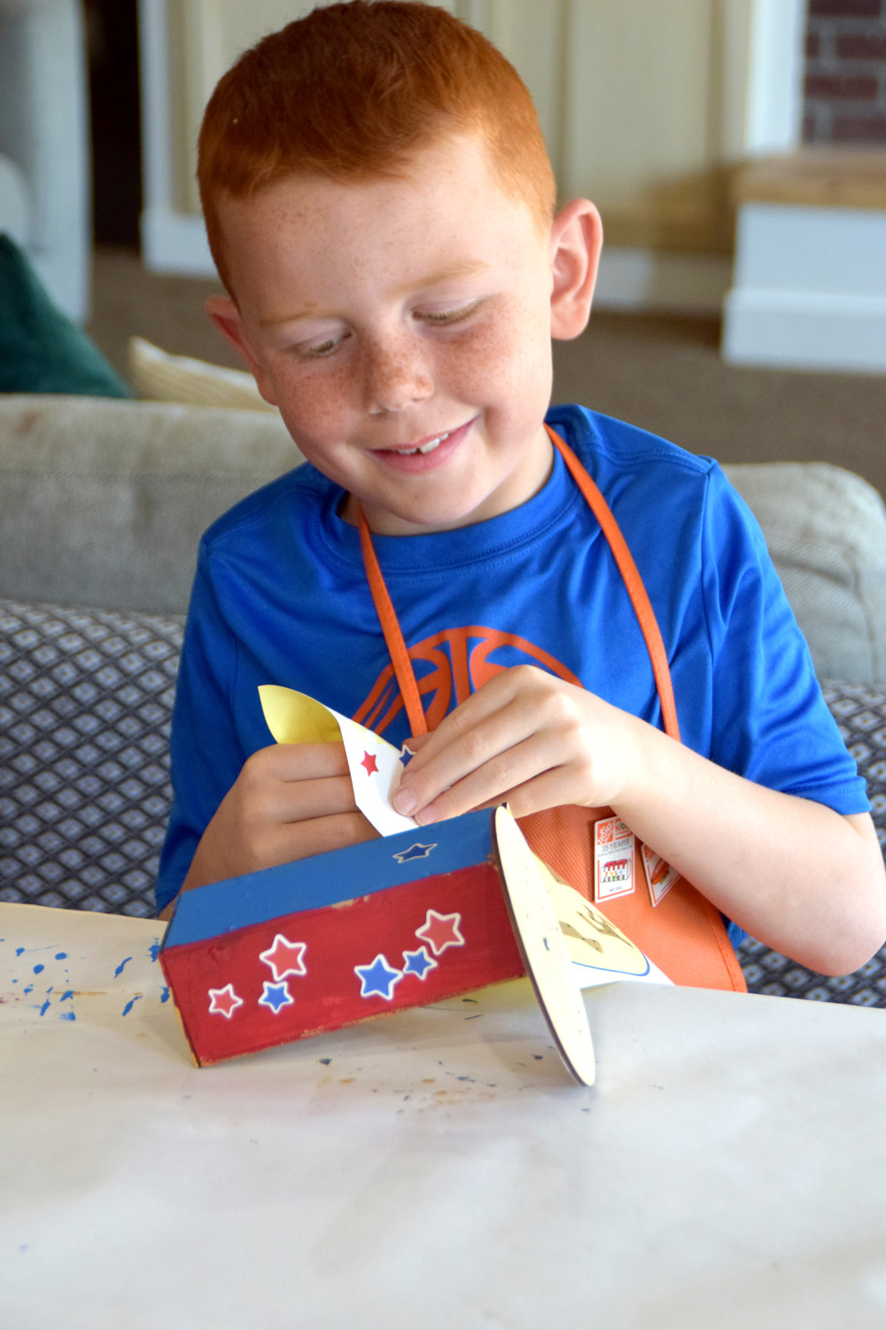 Boy adding red and blue stickers to a small viewer. 