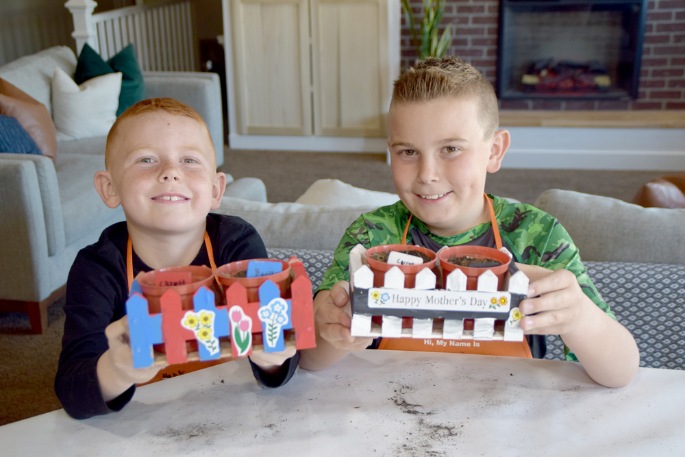 Two boys holding finished Picket Fence Planters.