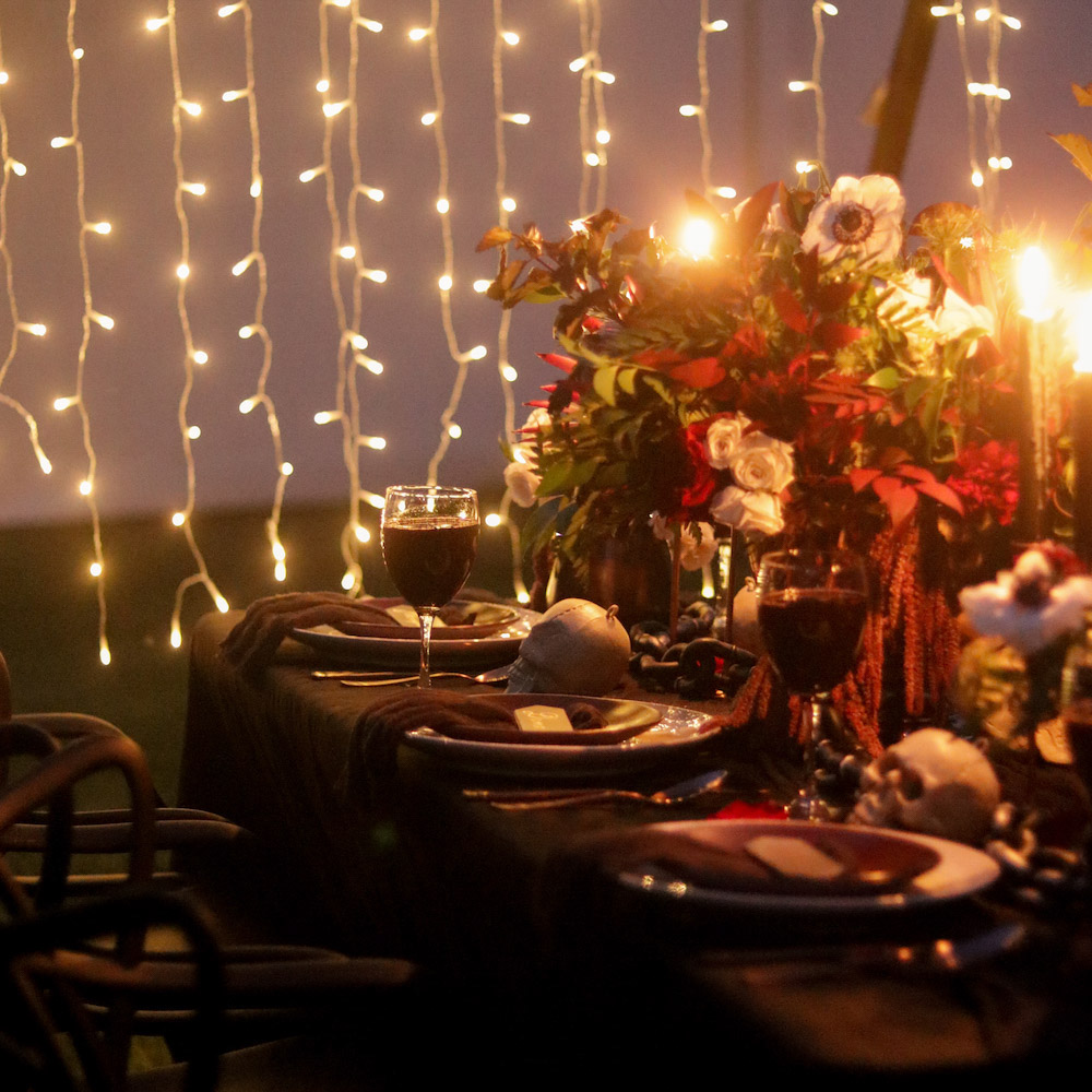 A Halloween tablescape lit by curtain lights.