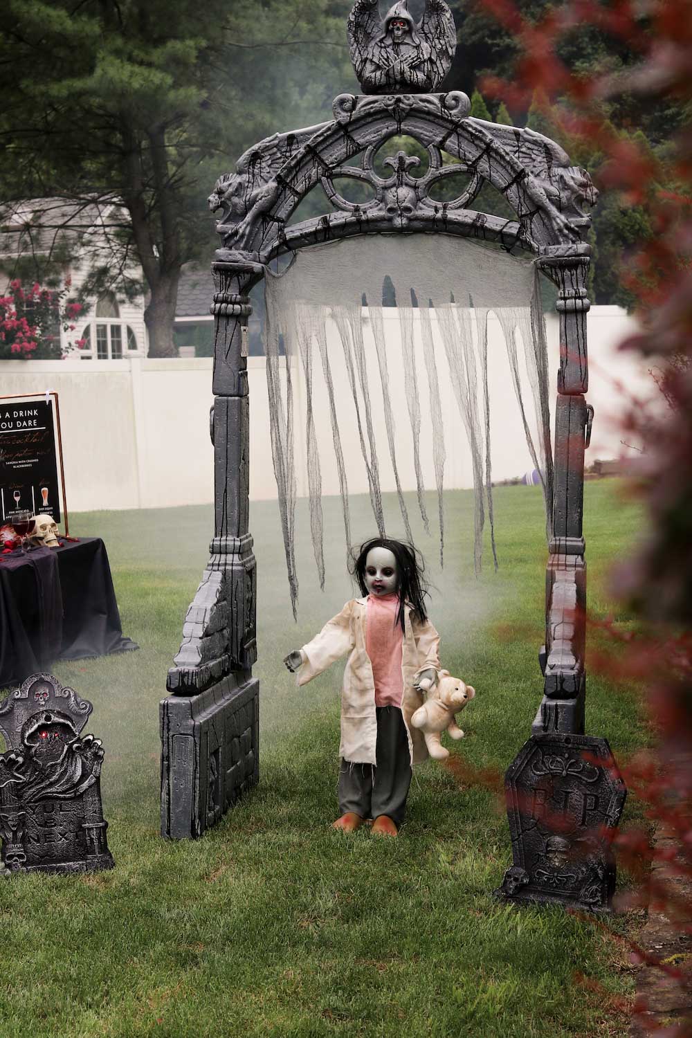 A zombie girl standing underneath a mausoleum archway.