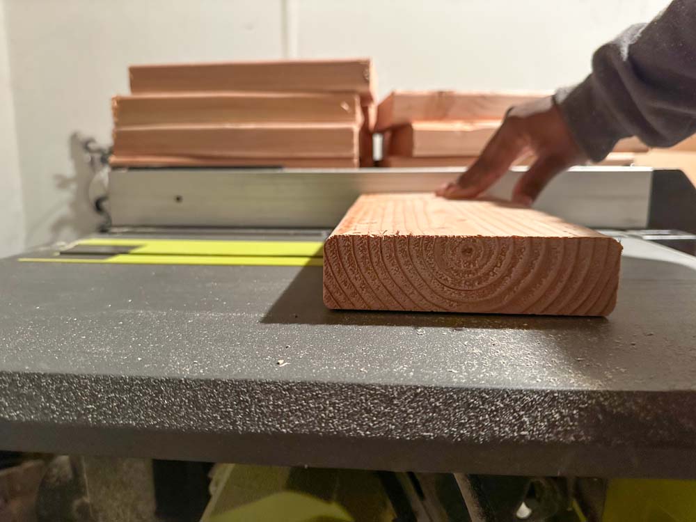 Woman cutting long lumber piece with table saw blade. Woman cutting long lumber piece with table saw blade.