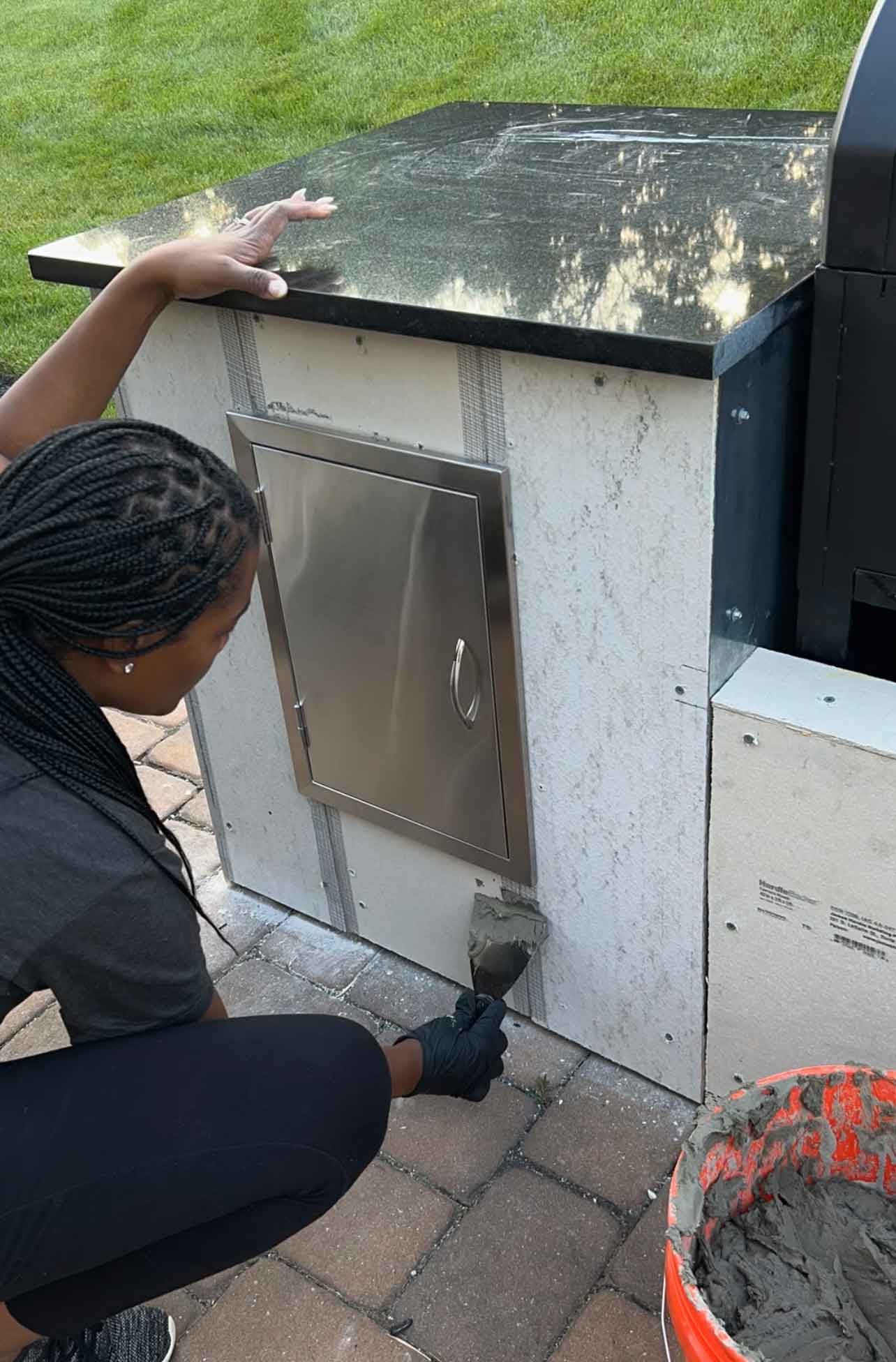 woman placing cement board tape over joints and corners