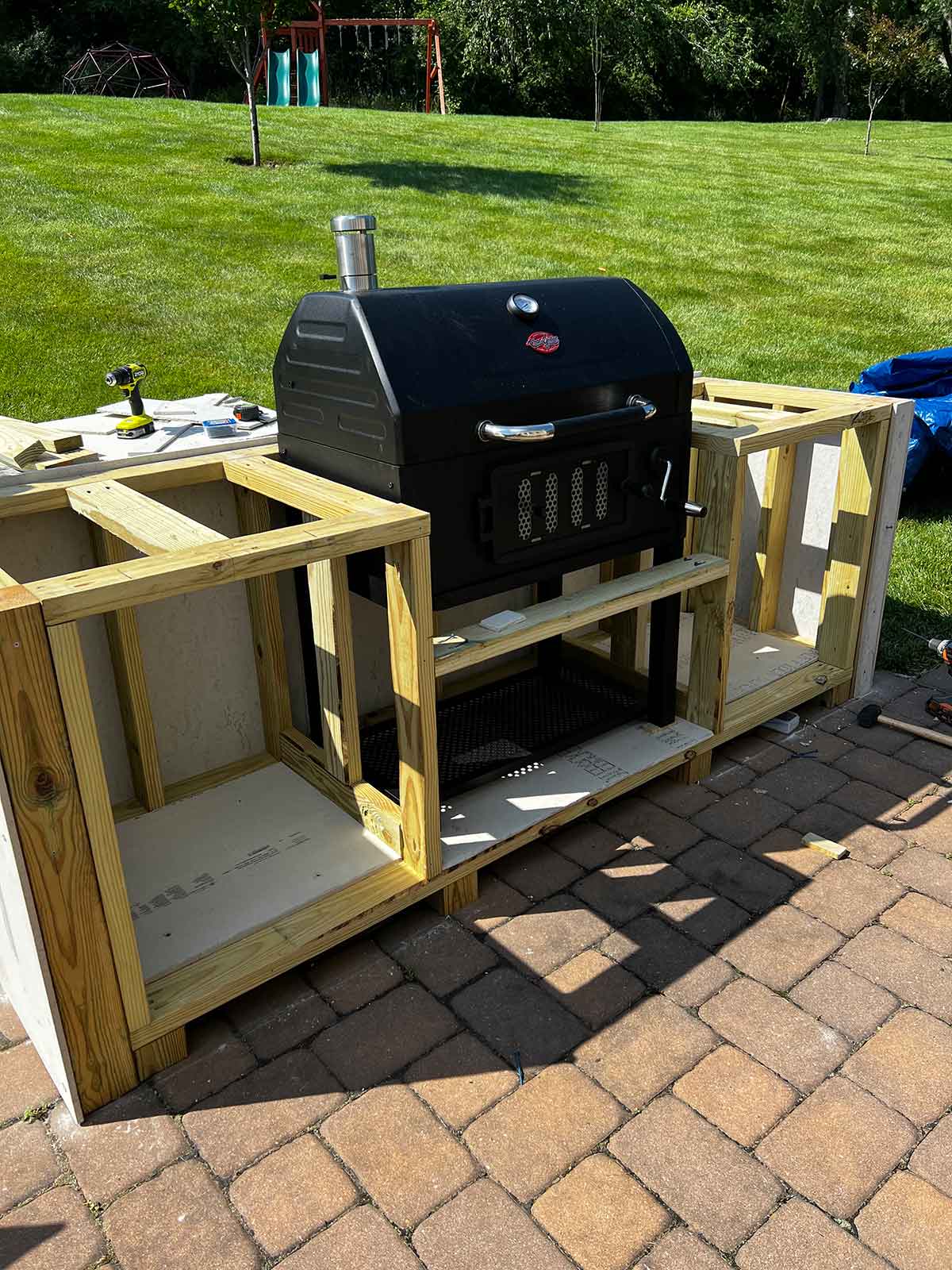 front of wood structure with grill placed in the middle and the backing installed
