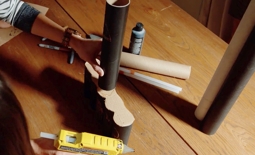 A person gluing a second level of castle pieces. A person gluing a second level of castle pieces.