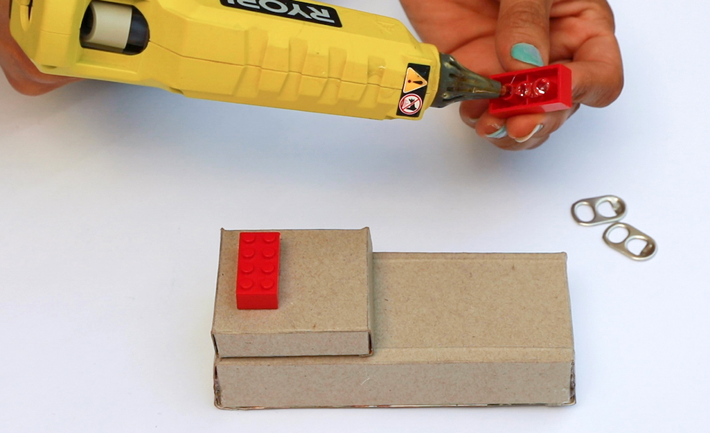 Person gluing the bottom of a LEGO piece.
