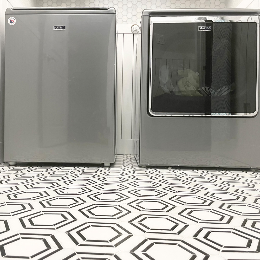 Washing machine and dryer with up close of floor tiling.