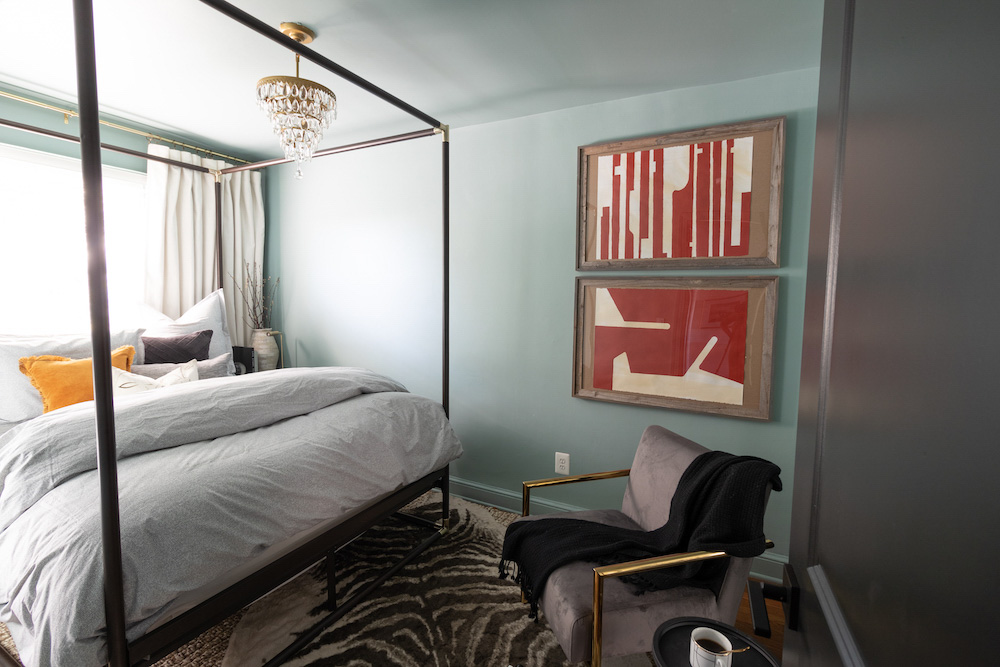 A bedroom featuring a zebra rug, chandelier, accent chair, and canopy bed. A bedroom featuring a zebra rug, chandelier, accent chair, and canopy bed.