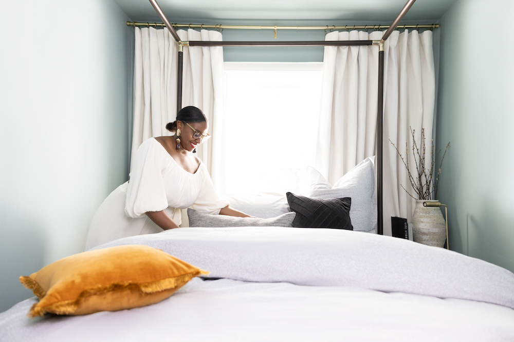 A woman making up a bed with a duvet cover and pillows. A woman making up a bed with a duvet cover and pillows.