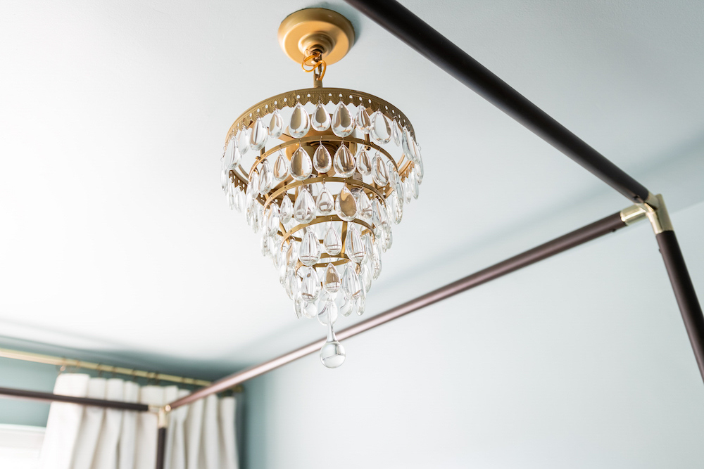 A brass and glass tear drop chandelier hanging from a ceiling. A brass and glass tear drop chandelier hanging from a ceiling.