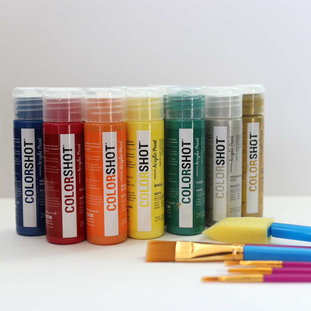 Rainbow of paints with a variety of paintbrushes.